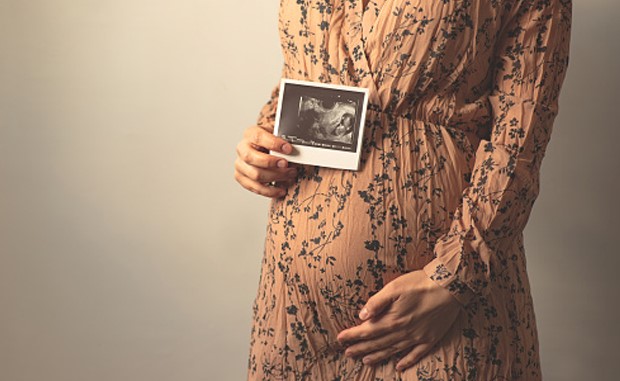 3 Ways Hospitals Are Tackling Maternal Health Innovation. A pregnant mother holding a fetal ultrasound image.