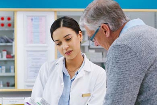 A pharmacist reviews drug information with a customer.