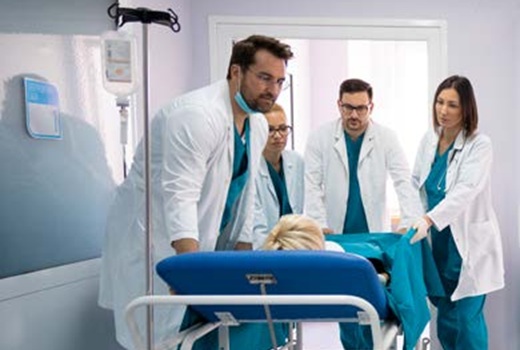 Clinicians at a hospital transport a patient in a hospital.