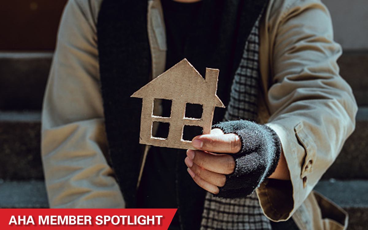 Trinitas Regional Medical Center Is Addressing Homelessness and Getting Results. An unhoused man presents a house cut out of cardboard. AHA Member Spotlight.
